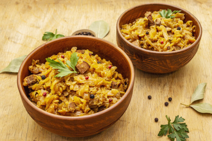 Tigelas rústicas com arroz carreteiro tradicional, decoradas com ervas frescas, em uma mesa de madeira.